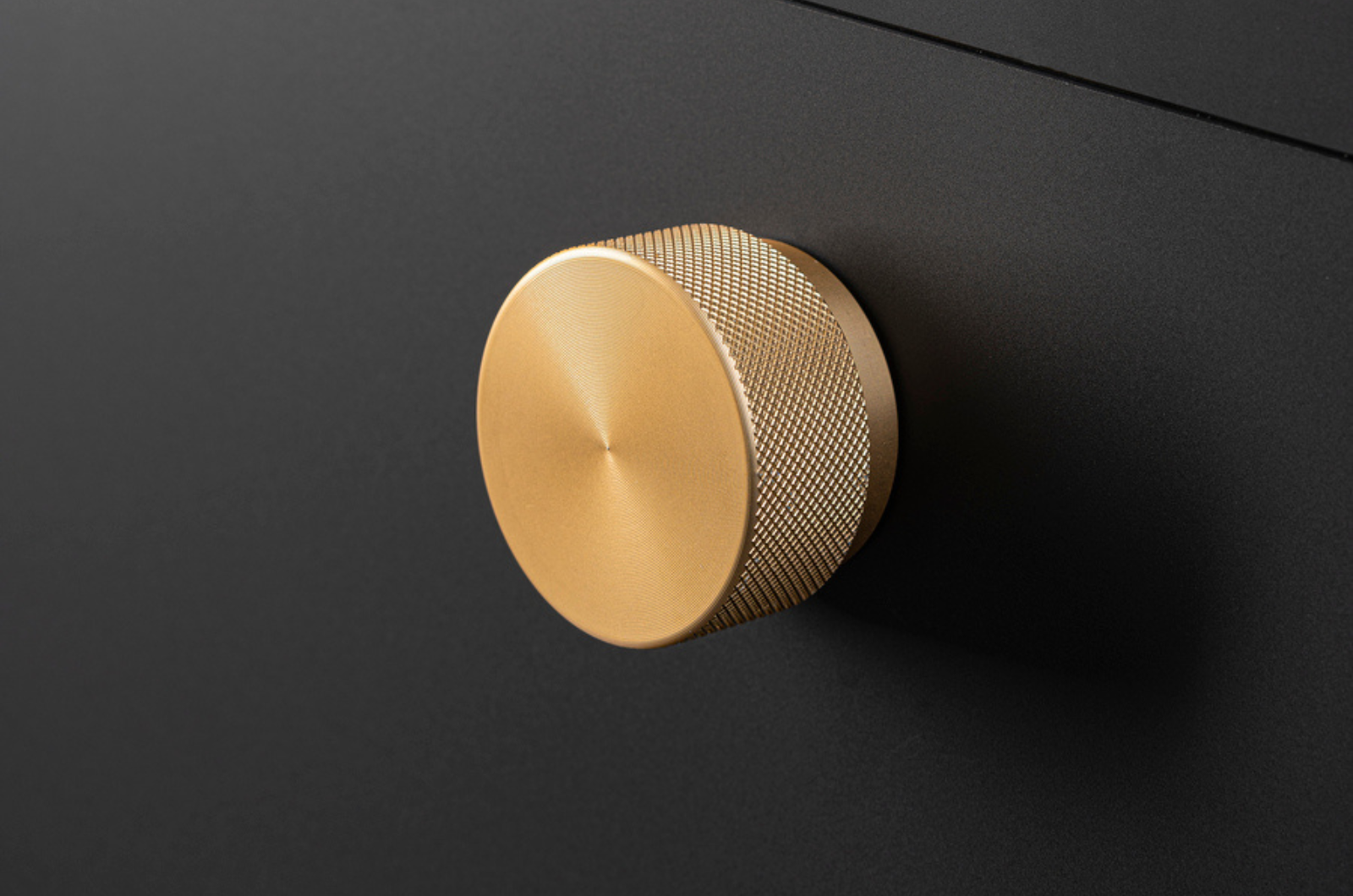 Bouton de meuble rond en laiton sur un meuble noir