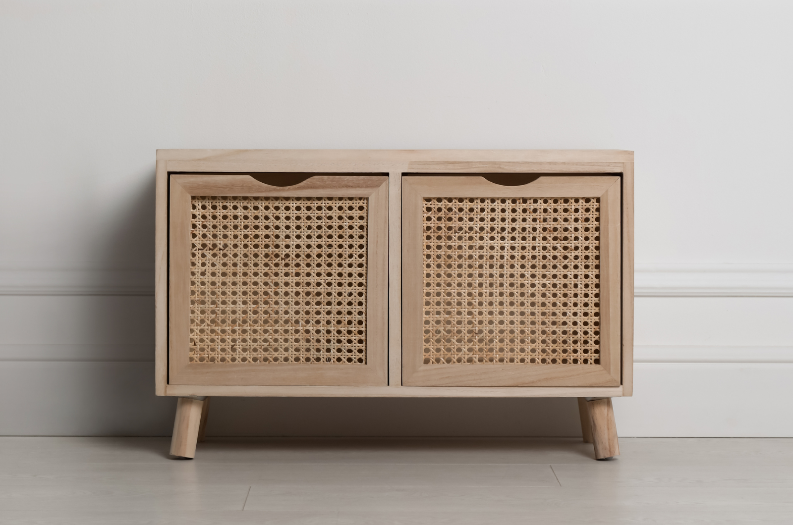 Commode en bois brut avec portière réalisée à base de rotin