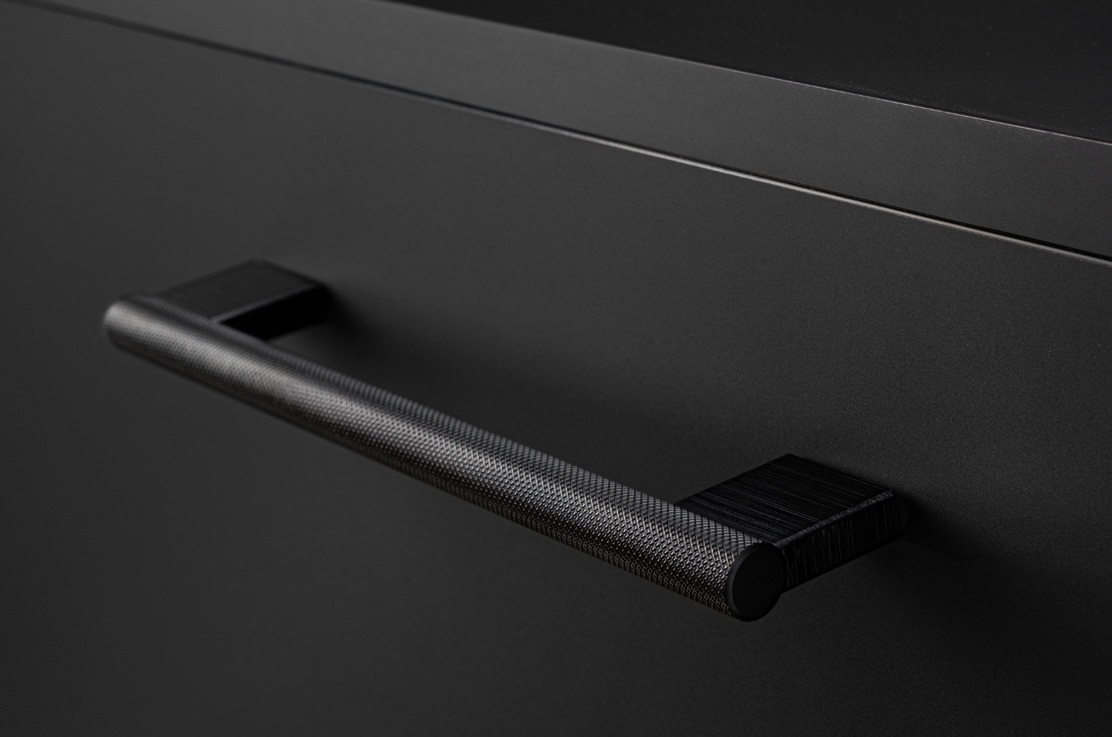 Poignée de meuble noir sur un meuble de couleur noir 