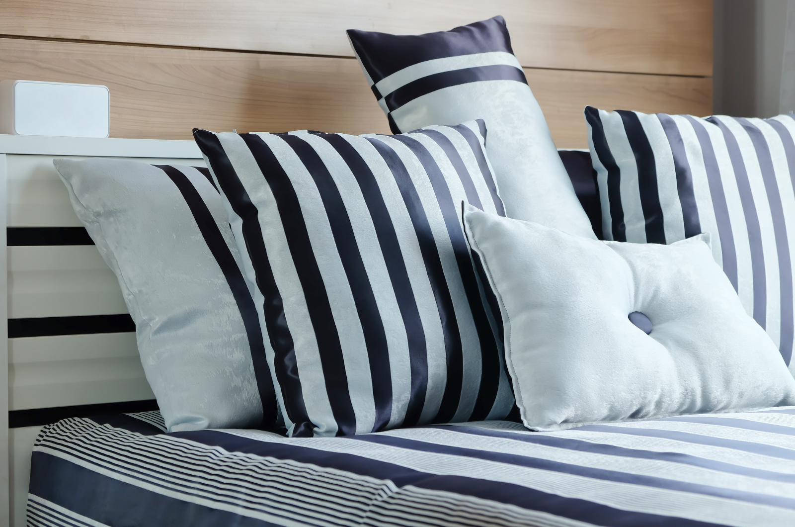 Coussins de plusieurs tailles et formats sur un lit